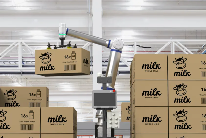 Palettázó robot dobozokat emel és raklapra rendez egy raktári környezetben.